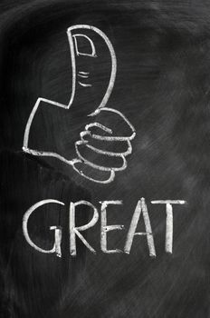 Thumb up with the word great drawn in chalk on a blackboard