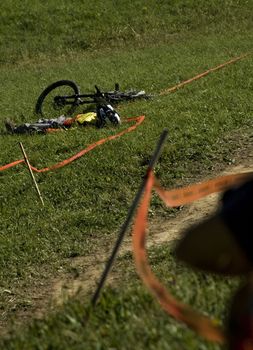 Shot of a downhill rider laying on the grass. Accident.