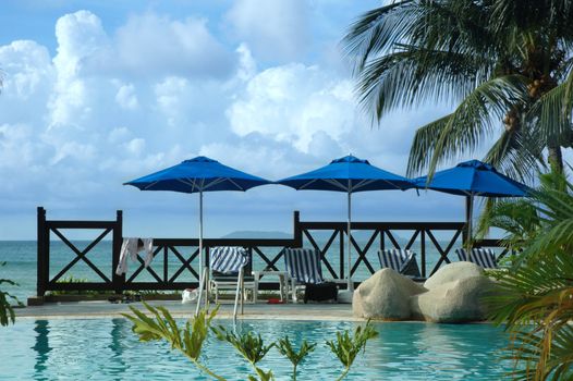 Summer poolside lounge next to tropical beach