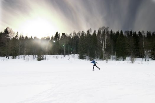 Skiing on a bright sunny day.  A winter landscape looking into the sun with lens flare.