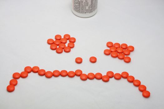 Pills normally taken for headaches and aches and pains, and placed in a sad face.