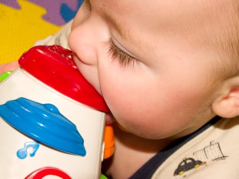 Closeup of a sweet  baby boy with a toy