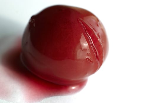 Berry of a cherry in a spoon with juice