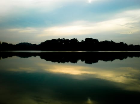 Beautiful reflection of the sky and clouds on the water with the sun shinning.