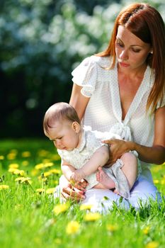 Happy mother and daughter on the green grass