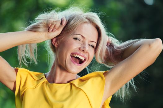 happy woman posing against a background of trees