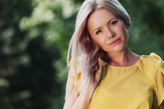 happy woman posing against a background of trees