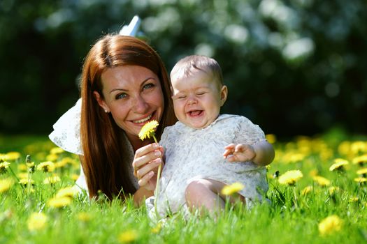 Happy mother and daughter on the green grass