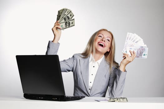 business woman working on laptop dollar in hands