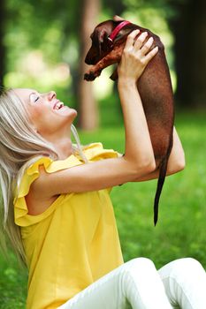 woman dachshund in her arms on grass