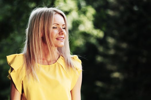 happy woman posing against a background of trees