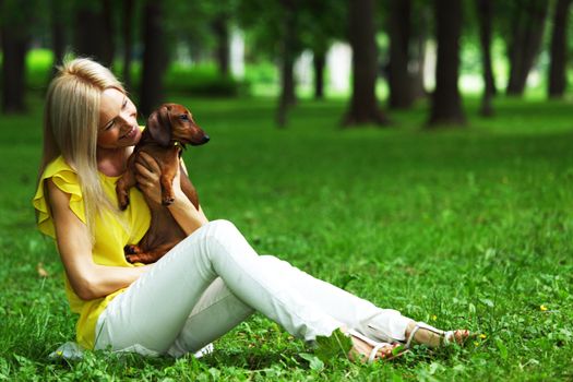 woman dachshund in her arms on grass