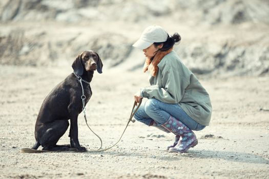 Tamer sitting with German short haired pointer outdoors