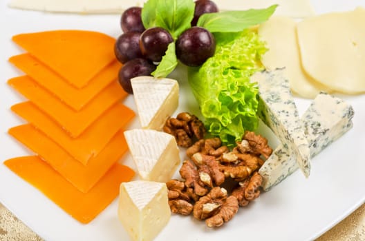 cheese with lettuce, grapes and nuts closeup