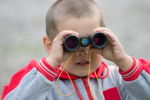 The boy in a wood, looks in the field-glass 