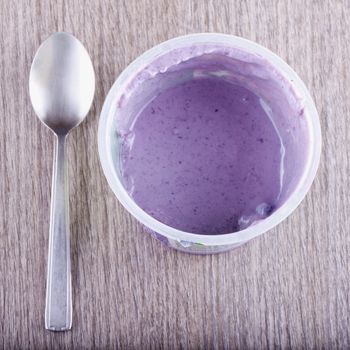 Close up of a cup of yoghurt over wooden table