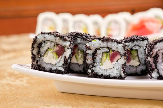 sushi roll with tuna, avacado, sauce and flying fish roe, closeup