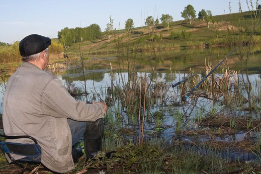 The fisher catches a fish in the river in the spring