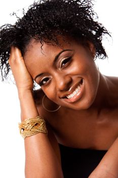 Face of a beautiful happy African woman smiling showing her white teeth and holding hand in curly hair, isolated.