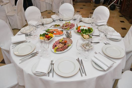 Served table with appetizers, dishes and glasses.