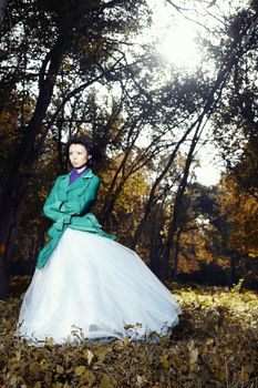 Brunette lady standing in the autumn forest