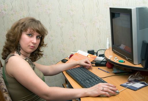 The young girl works behind a computer