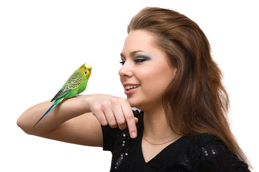 The girl talks to a green parrot