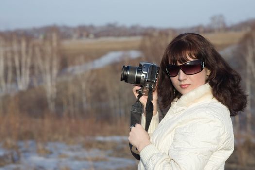  girl with the camera on a background of a spring wood