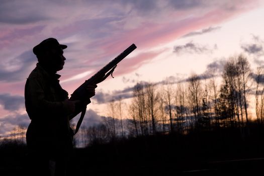 Silhouette of the hunter on a background of a morning dawn