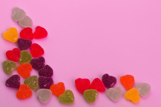 Love-shaped jelly on white background under pink gel illumination for background use