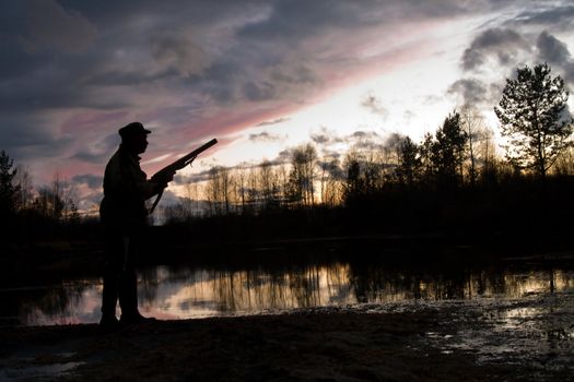 Silhouette of the hunter on a background of a morning dawn