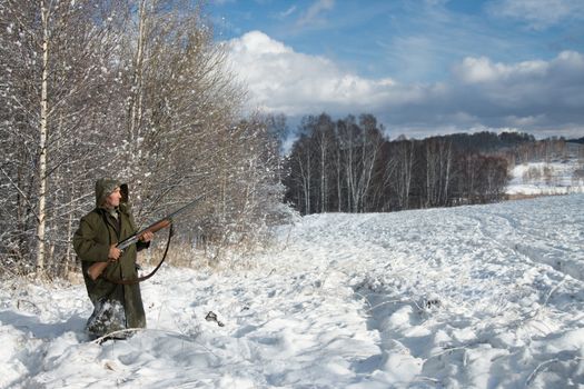 The hunter in the winter on a marge of a wood