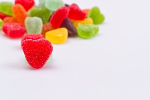 close up view of the red love-shaped jelly on white surface