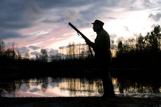 Silhouette of the hunter on a background of a morning dawn