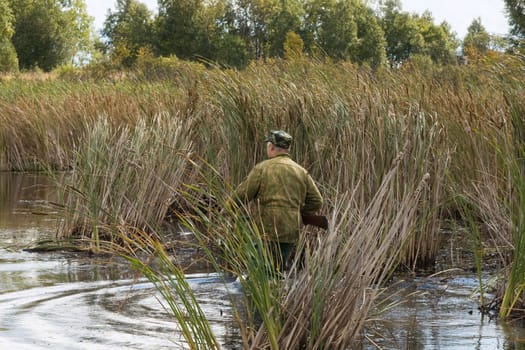 The hunter goes on lake in search of wild ducks