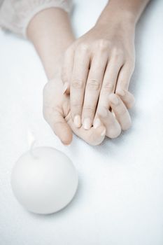 Woman hands in spa saloon with white candle