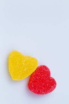 Yellow and Red Love-shaped jelly on white surface with copy space for backround use in portrait orientation