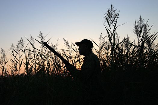 Silhouette of the hunter on a background of a morning dawn