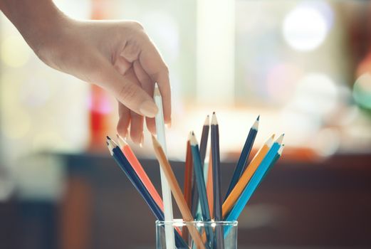 Human hand taking taking pencils