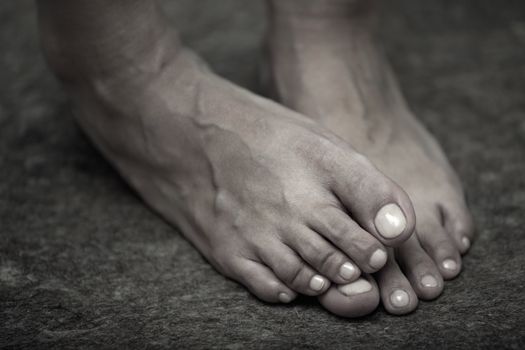 Feet of adult woman on a dark background