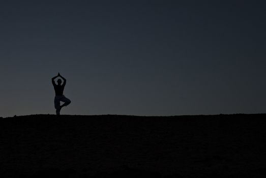 Male model practicing Yoga on the beach at sunset, Red Sea, Egypt