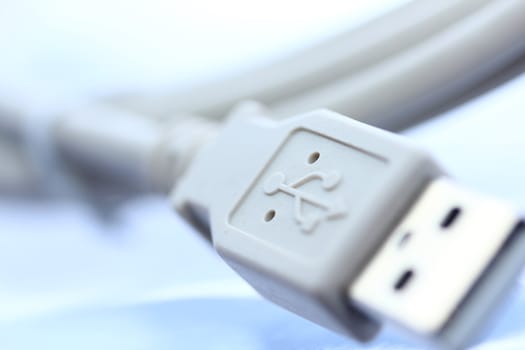 A wired USB cable sits on a surface.