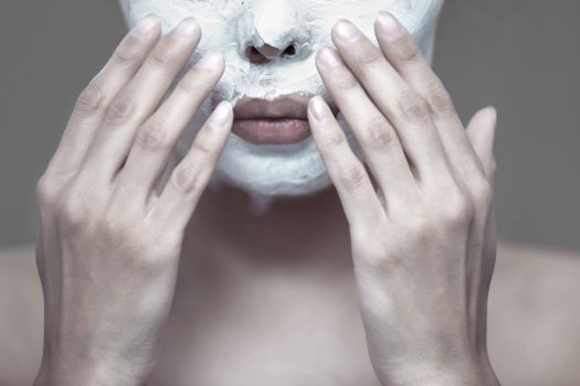 Woman applying moisturizing cream to the face