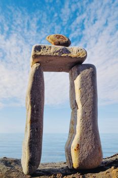 Balancing of elongated pebbles on the sea boulder