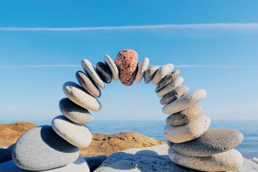 Red round stone in center of arc of the pebbles