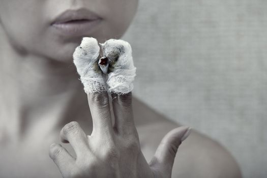 Woman with burnt fingers smoking cigarette stub