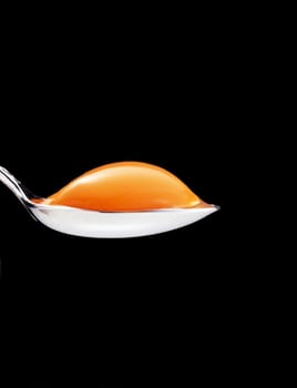 yolk in the spoon on a black background