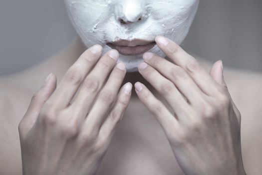 Woman applying moisturizing cream to the face