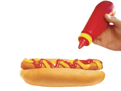 a ketchup squirt bottle in a persons hand on white