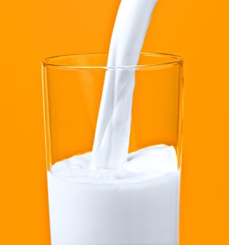 pouring milk in a glass isolated